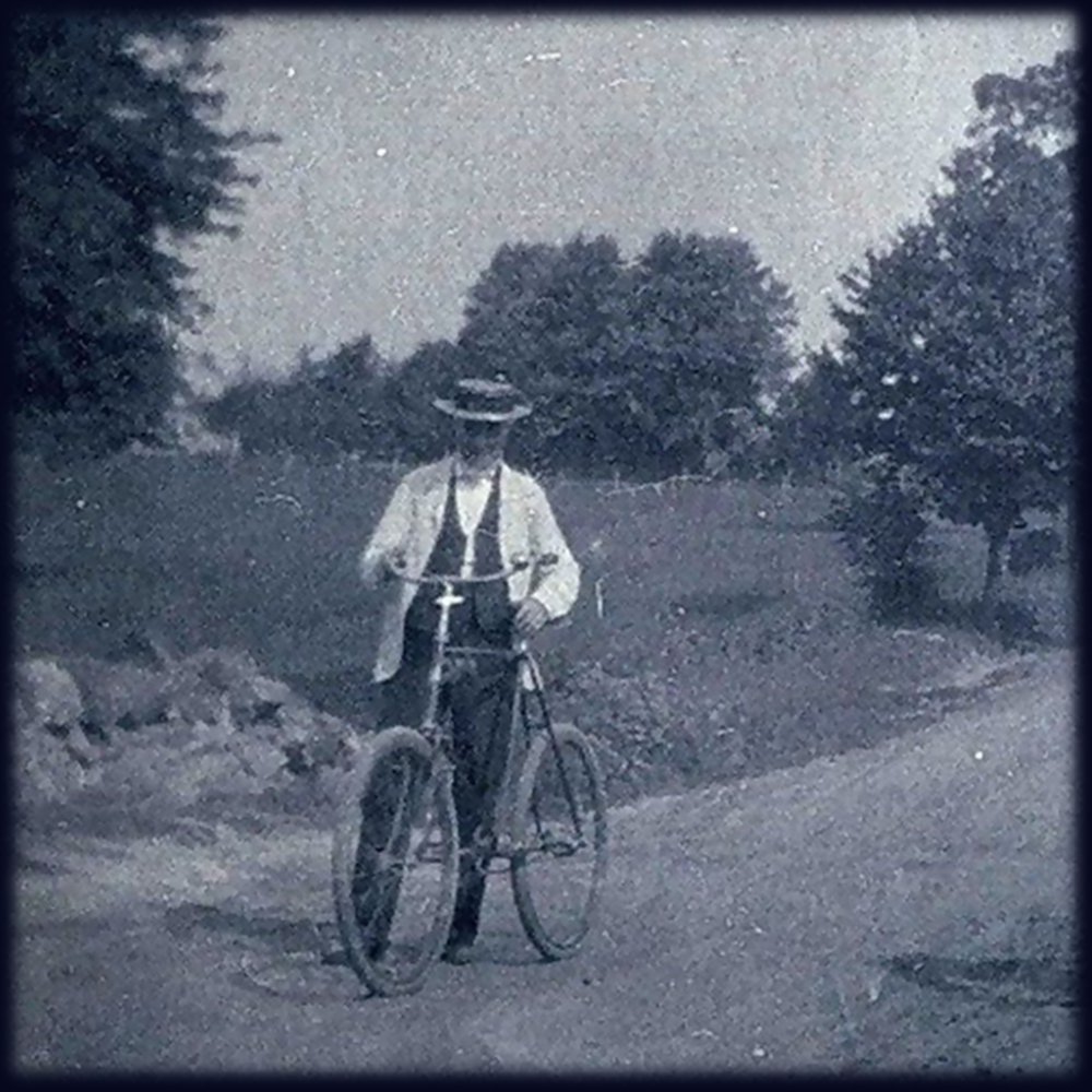 19th century photo of a man with a bicycle